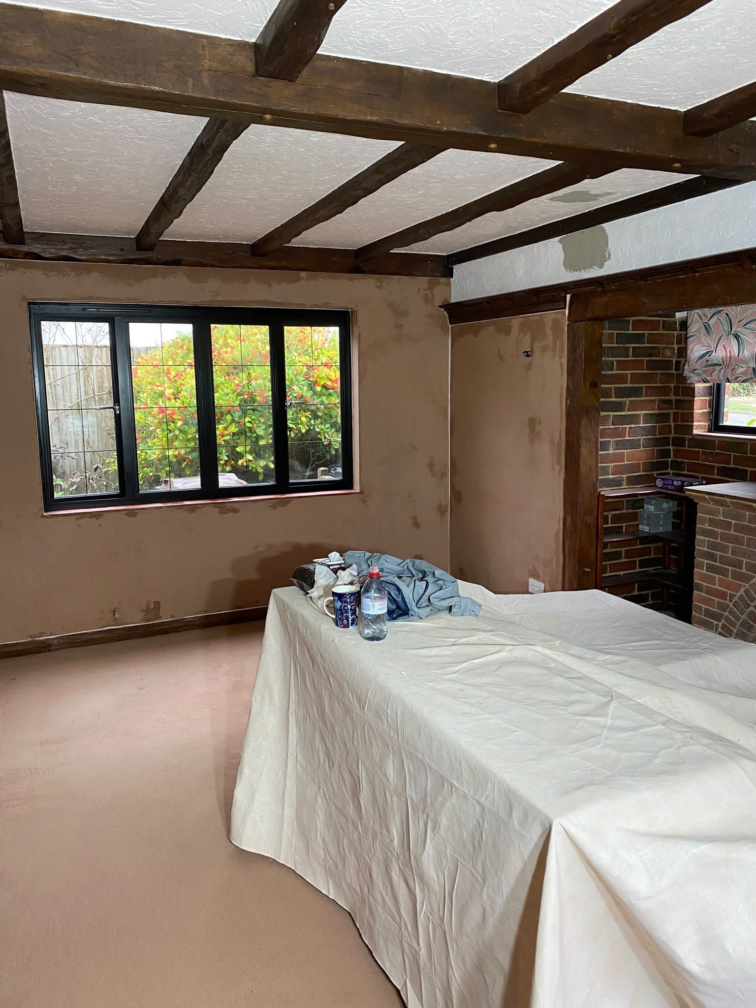 Beamed room walls skimmed by the fireplace, during