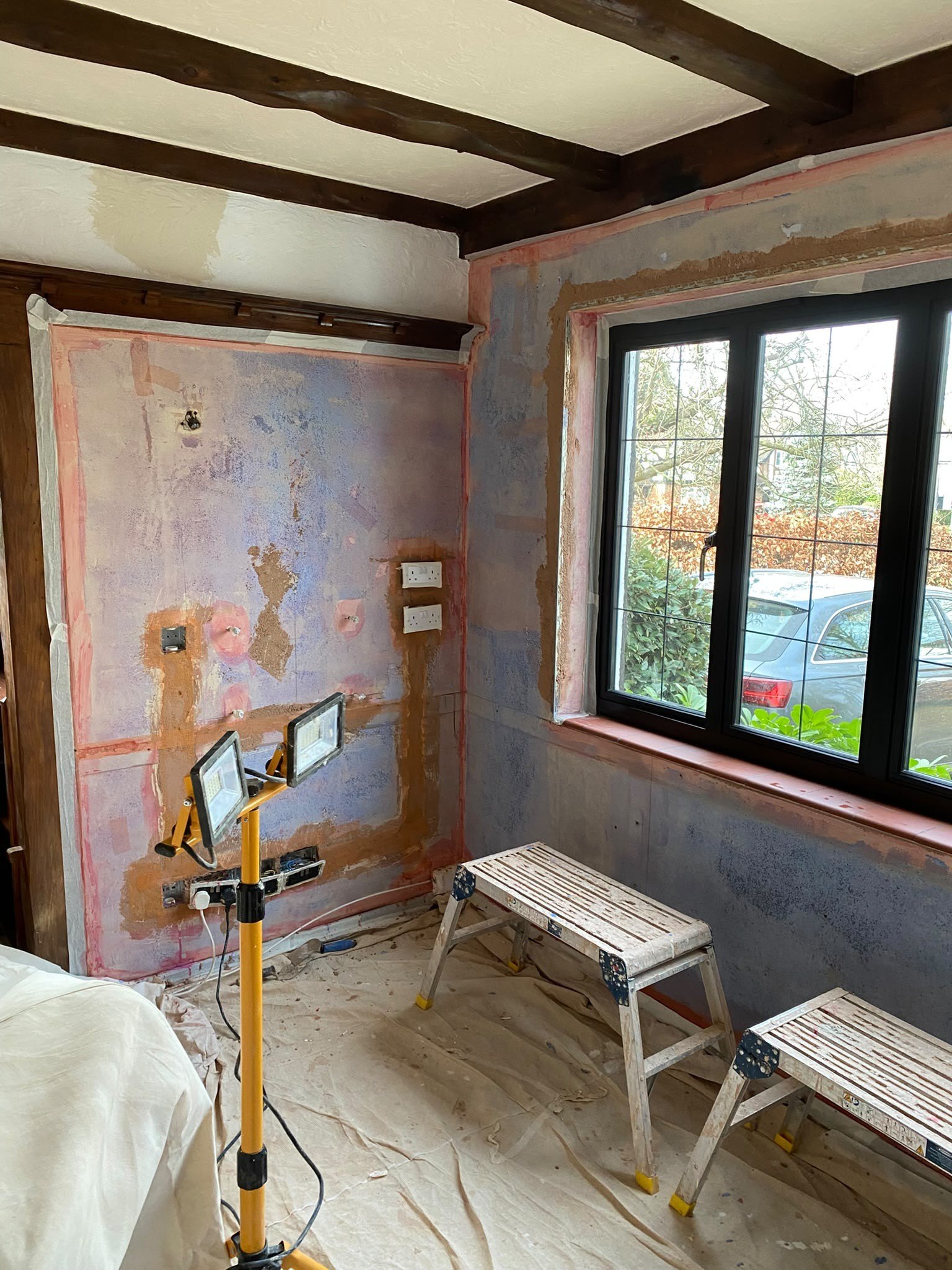 Beamed room walls stripped back, before