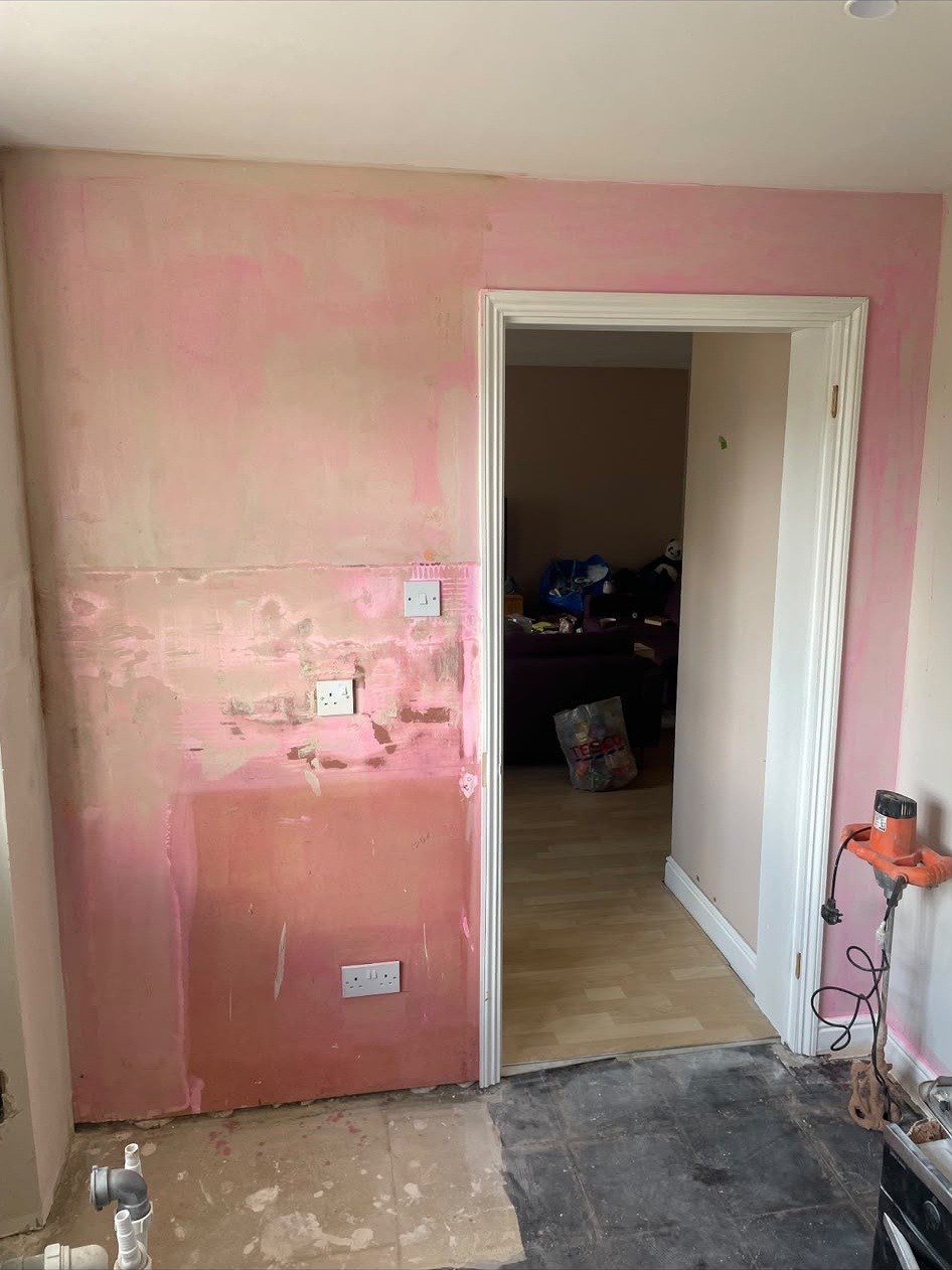 Room wall stripped and prepped, before