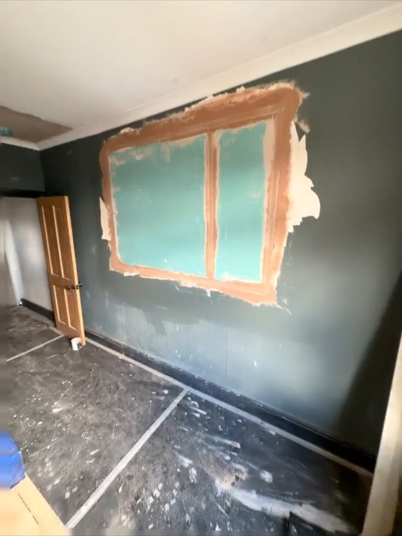 Wall patch boarded and taped ready to skim, during