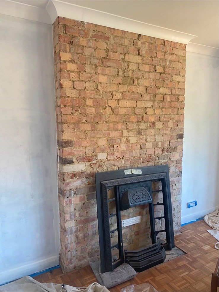 Chimney breast stripped back to brick, before