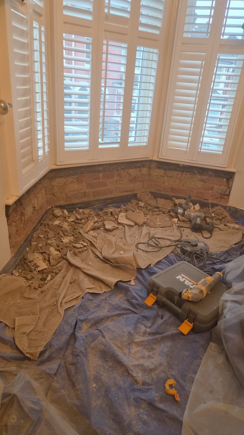Bay window wall stripped to brick, before