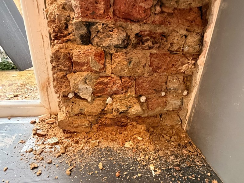 Damp door pier stripped, before
