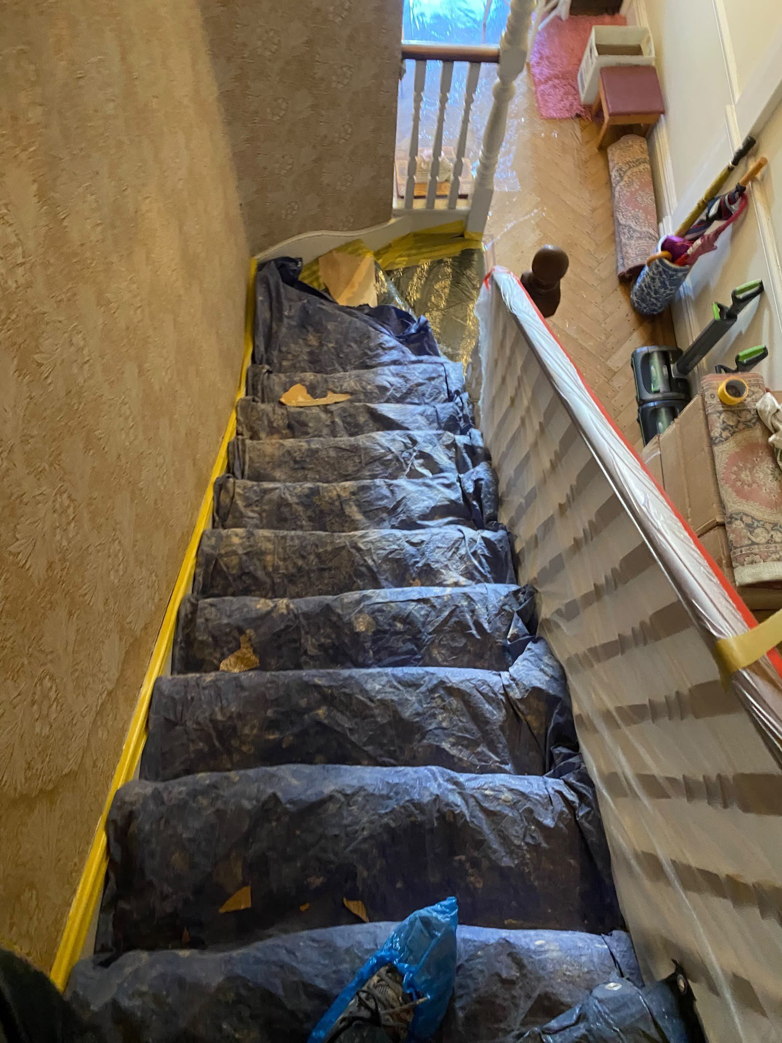 Staircase sheeted and taped for dust, during