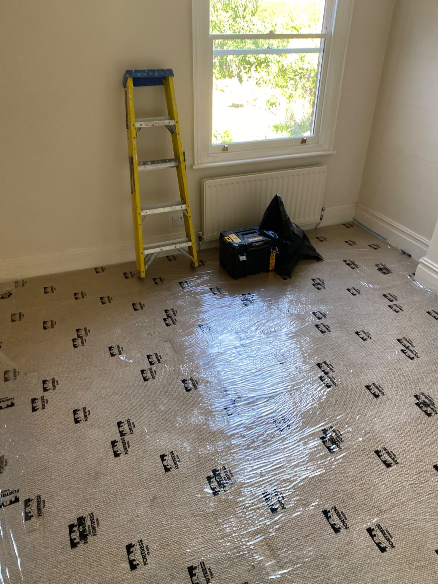 Floor protected with boards before ceiling work, during
